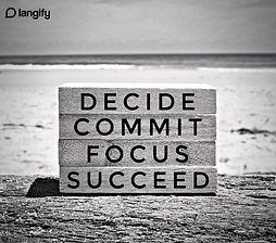 wooden block sign at the beach with Decide Commit Focus and Succeed written